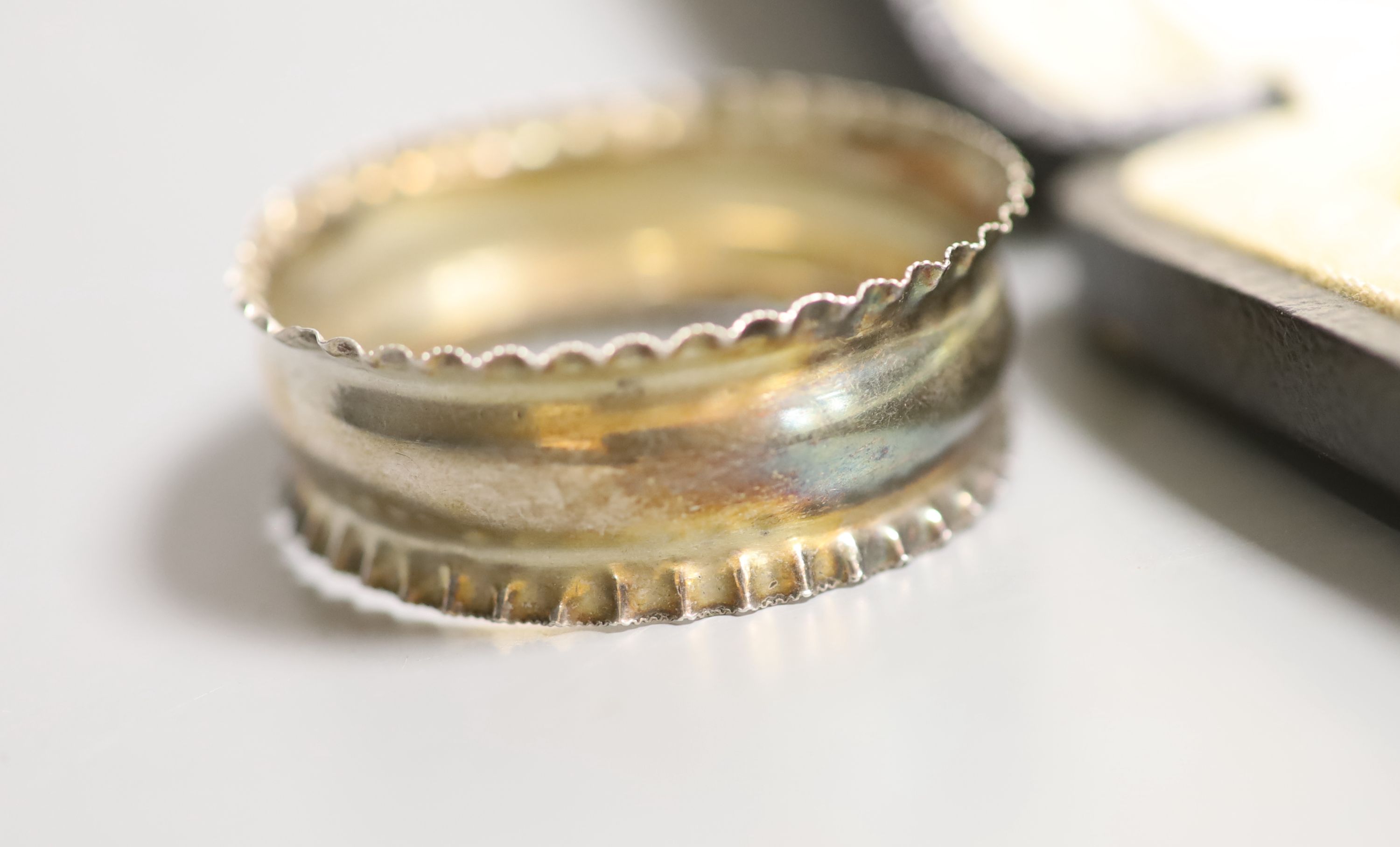 A cased set of six silver and enamel(a.f.) bean end coffee spoons, one other silver spoon, a silver napkin ring and small silver trophy cup.